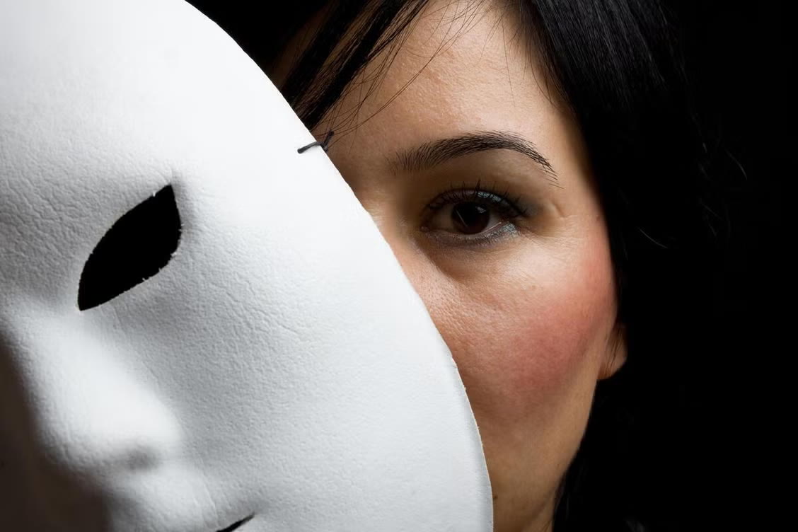 Visage à moitié caché par un masque blanc